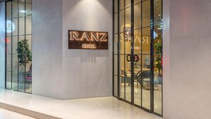 Exterior del Hotel Ranz, con un diseño moderno, que destaca un letrero llamativo y amplias puertas de cristal.