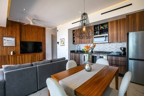 A modern kitchen with a built-in oven, microwave, and stainless steel refrigerator.