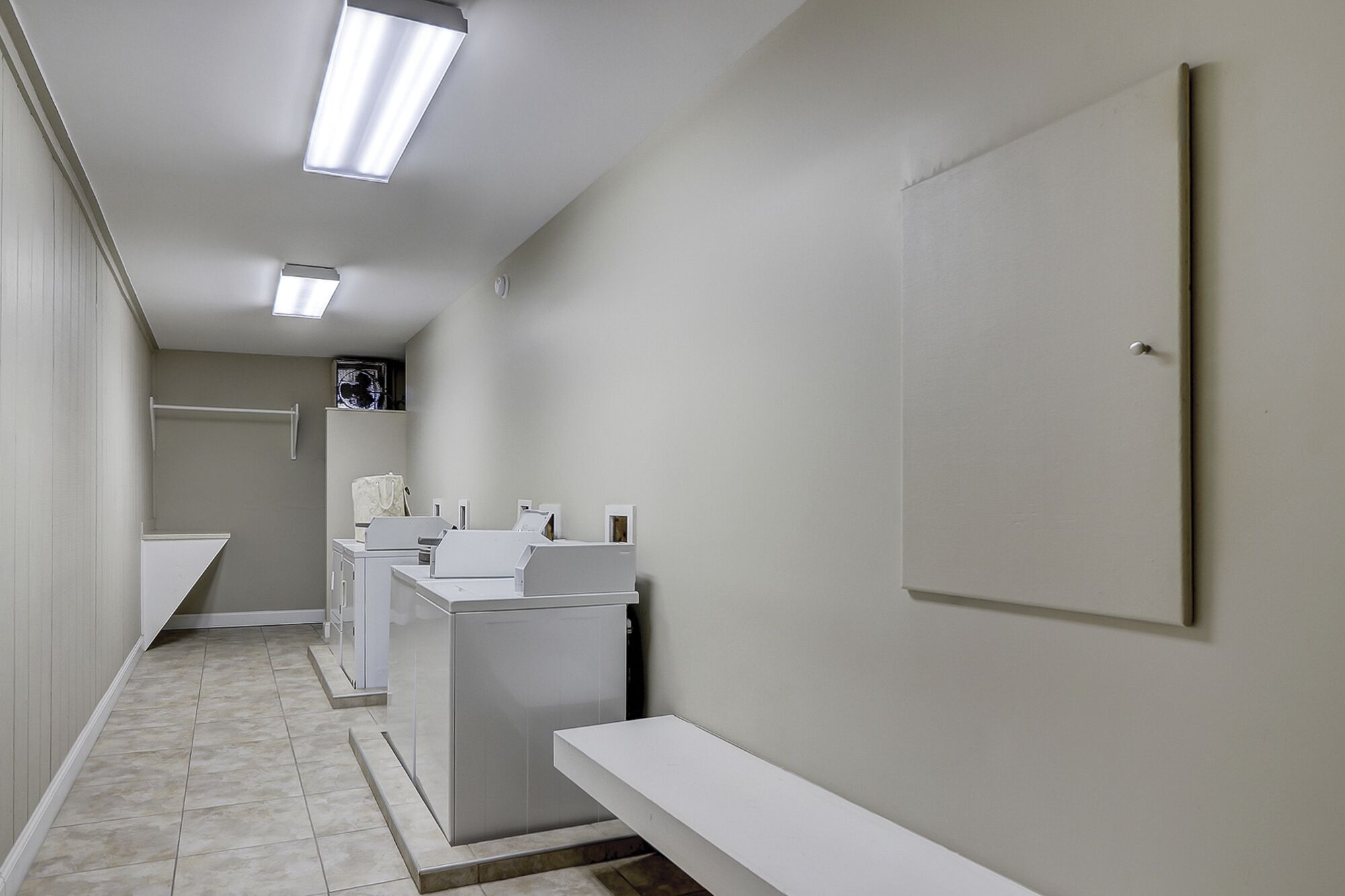 Une salle de bain propre et moderne, avec des éléments d’aménagement blancs et un sol carrelé.
