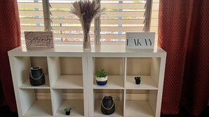 Een witte wandplank met decoratieve voorwerpen en borden.
