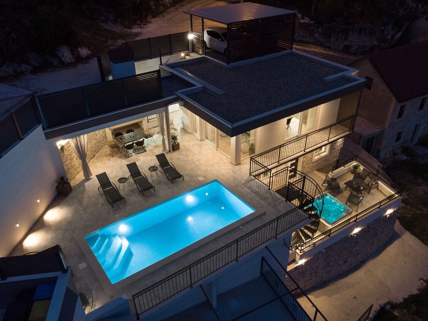 A modern two-story house with a swimming pool, outdoor seating, and a covered patio area.