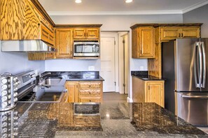 Enjoy cooking in this kitchen with a gas stove, microwave, and ample workspace on the granite countertop.