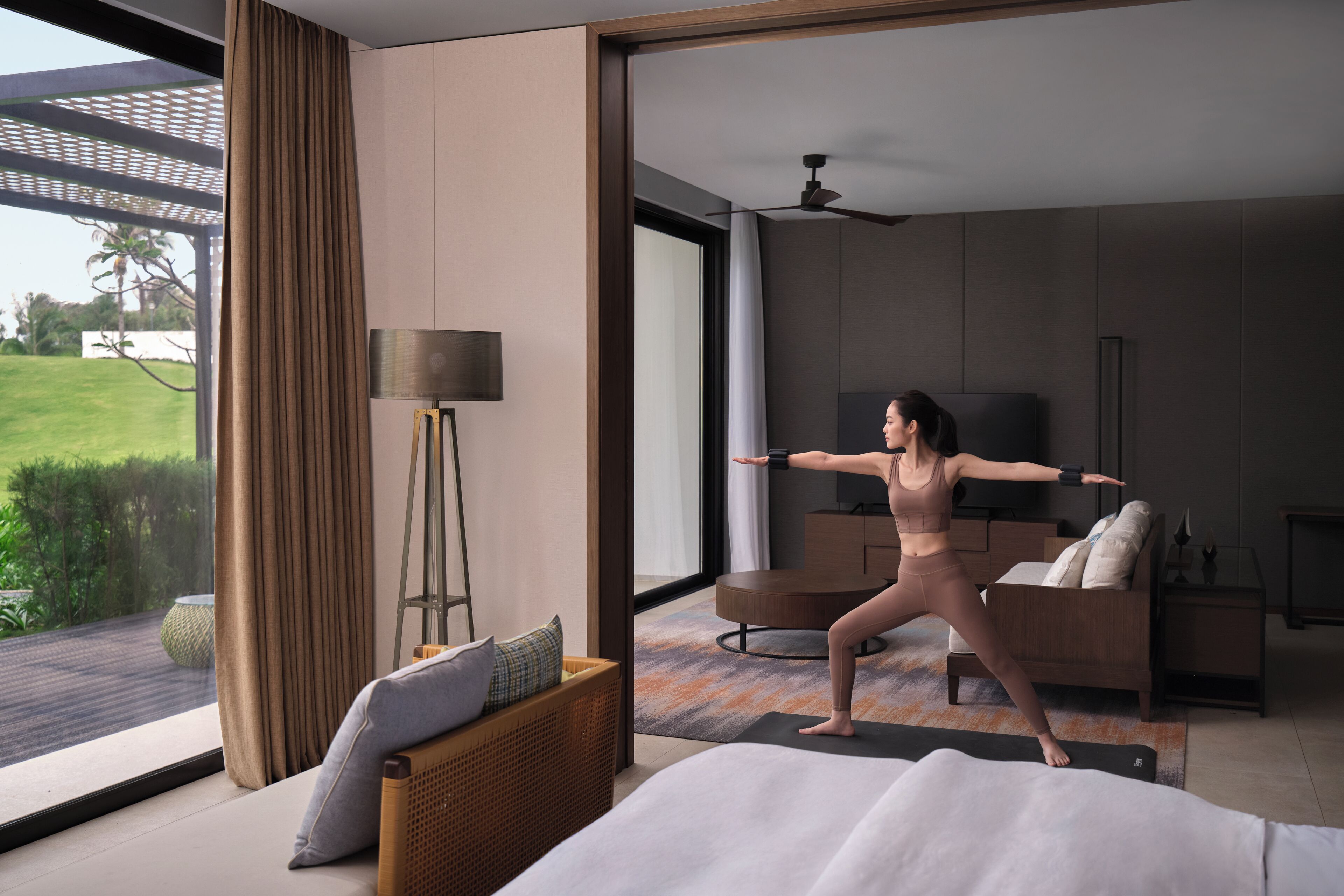 Une chambre à coucher moderne avec un lit, une lampe sur pied, un canapé et un téléviseur.