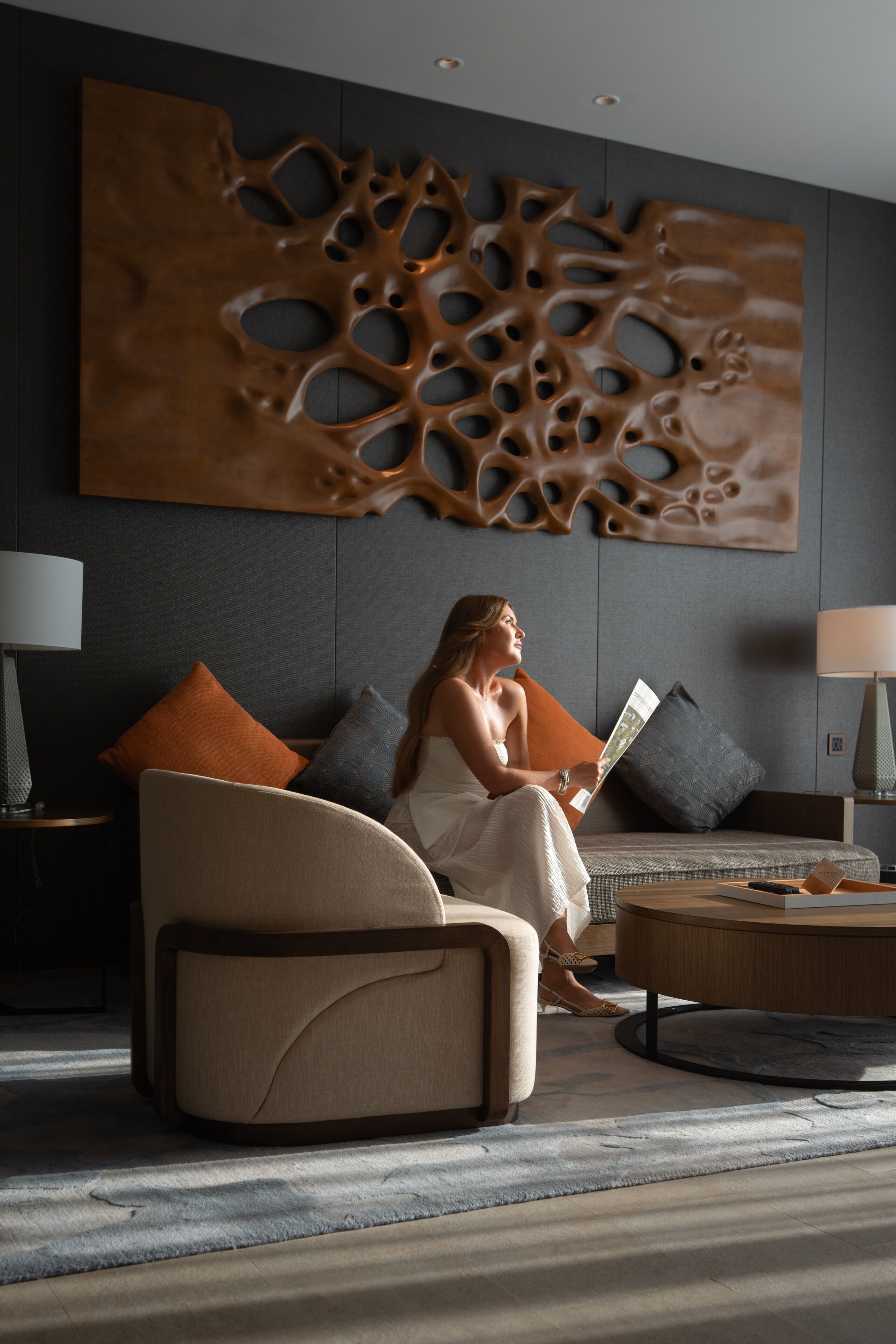 A modern living room with a sofa, a coffee table, and a large abstract wall art piece.