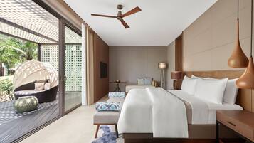 Un dormitorio moderno con una cama grande, ventilador de techo y vista al exterior.