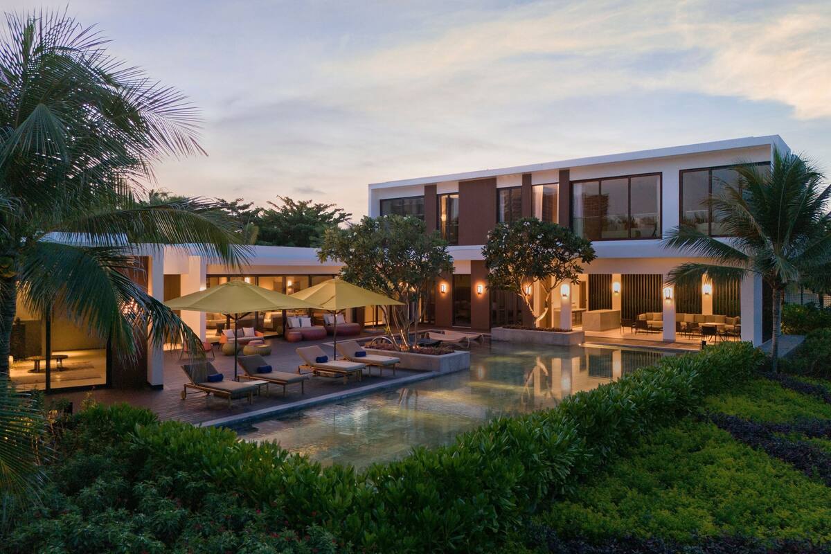 A modern resort with a swimming pool, lounge areas, and a well-maintained garden.
