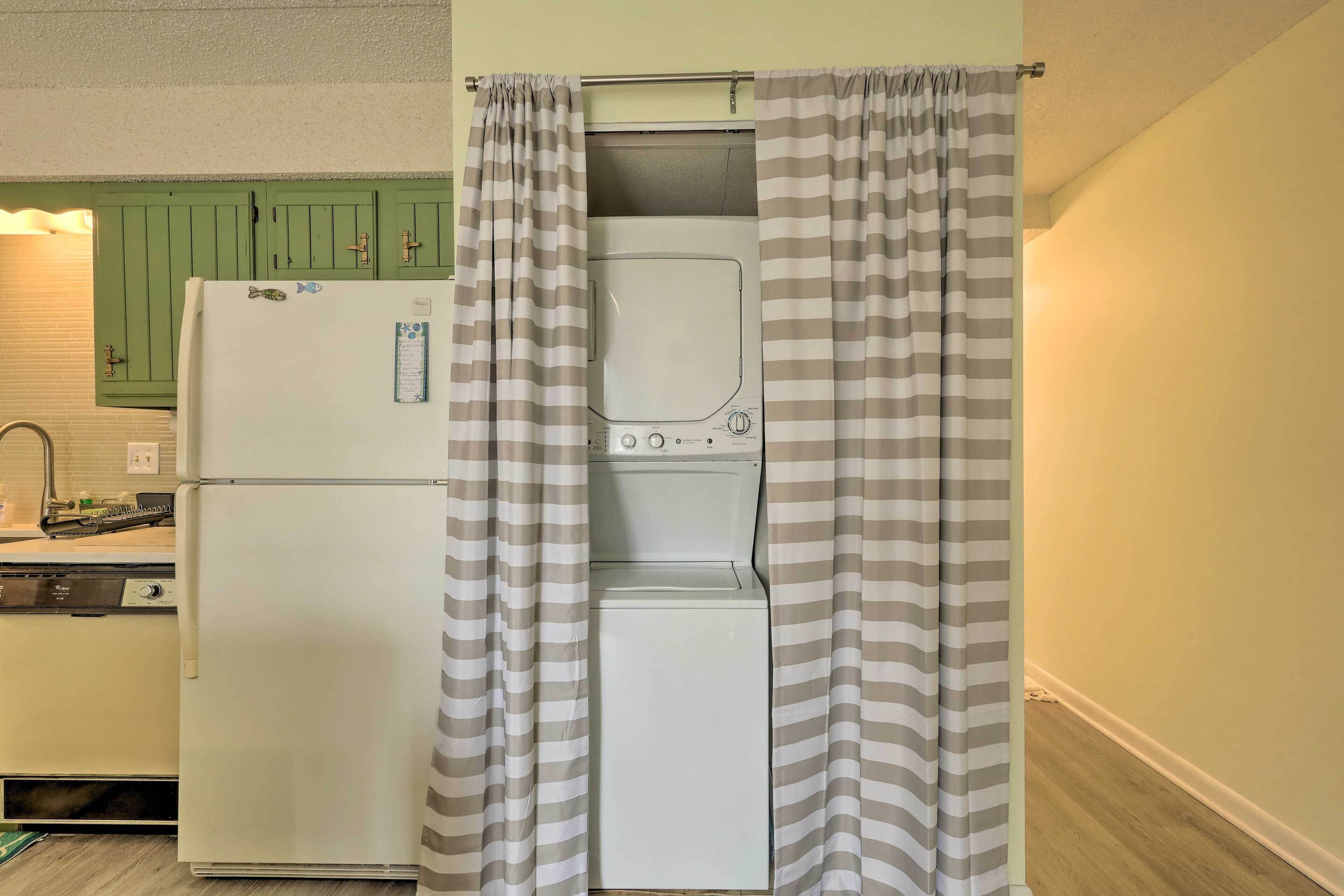 A compact kitchen with a white refrigerator, a built-in oven, and a dishwasher.