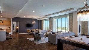 Una sala de estar moderna con mesa de billar, sofá y zona de comedor.