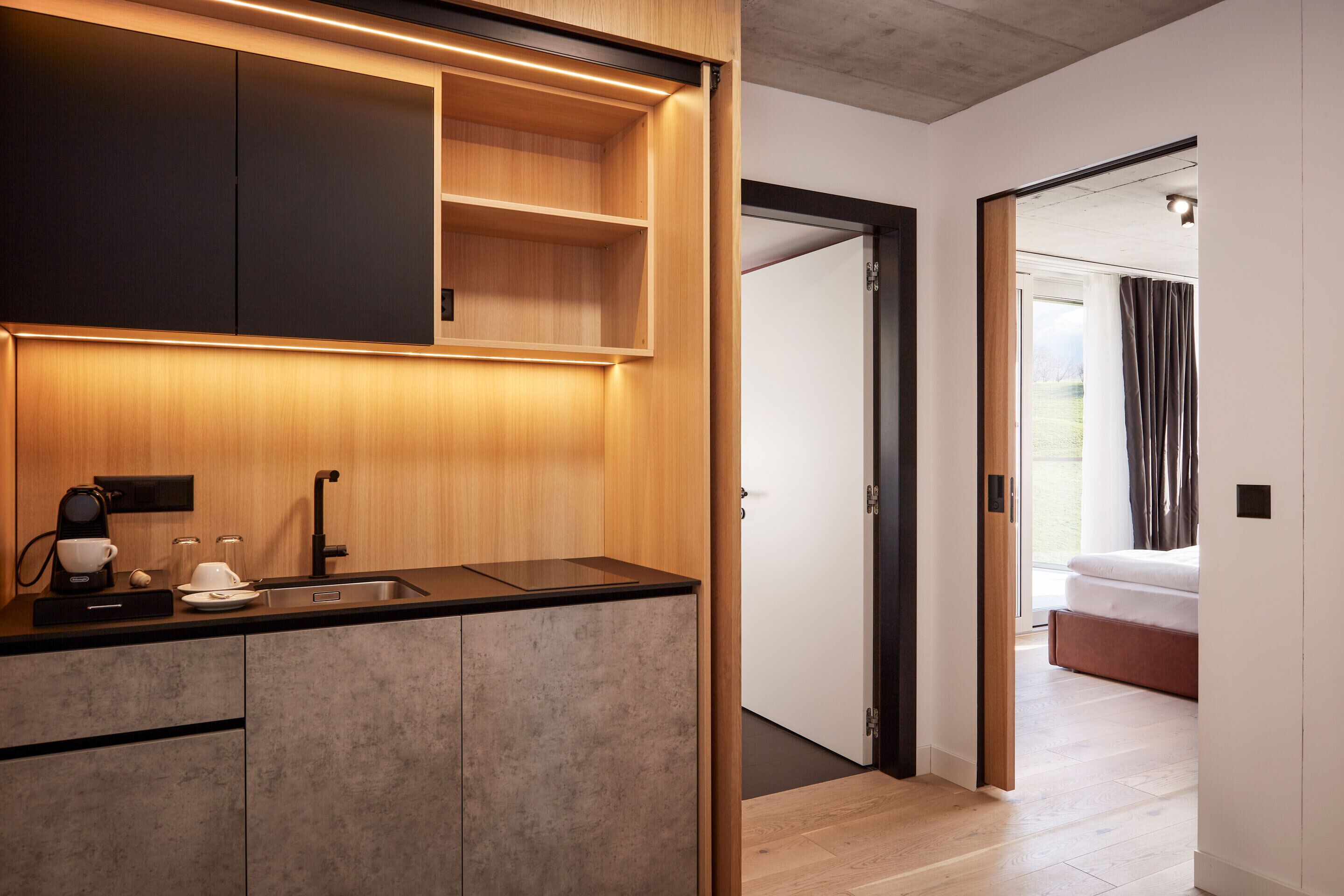 A modern kitchen with a built-in oven, a coffee machine, and a sink.