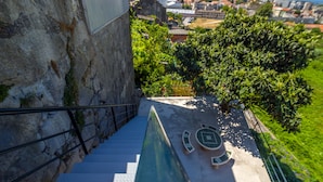 Una escalera conduce a una terraza en la azotea con piscina y mobiliario exterior.