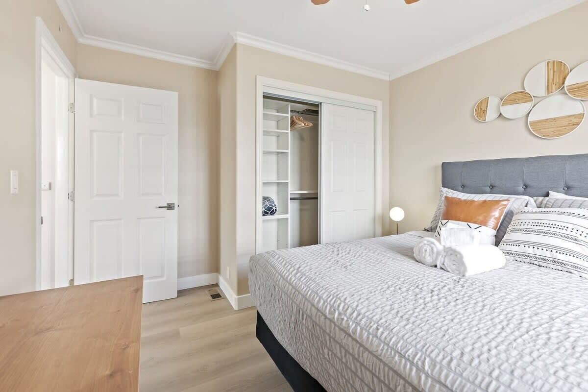 A bedroom with a bed, a wardrobe, and a bedside table.