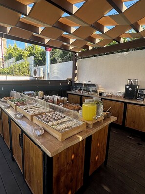 An outdoor buffet area with various food items and a coffee station. - Oikos Bozcaada (Bozcaada)
