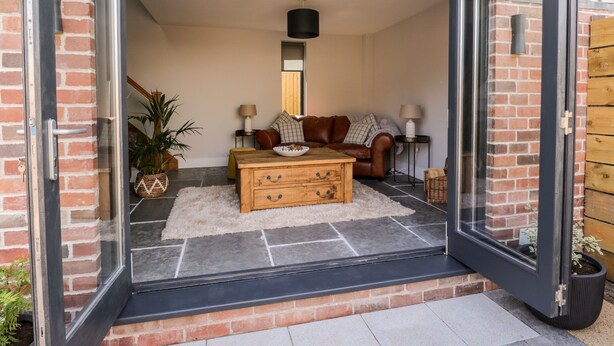 A modern living room with a sofa, coffee table, and lamps. - Little Lugg (Hereford)