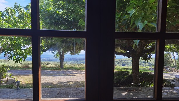A view through a window with a stone floor, trees, and a distant landscape. - Domaine de La Calm: In a nature park with breathtaking views of the Pyrenees (Villardonnel)