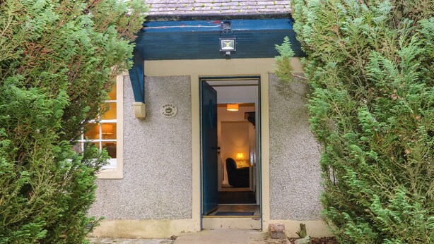 A stone building with a dark blue door and a sign reading "North Lodge". - North Lodge (Forfar)