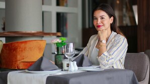 A person seated at a table with a vase of flowers, a wine glass, and a salt and pepper shaker. - Urban Hotel and Spa (Kenitra)