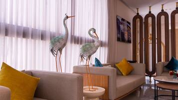 A modern living room with two sofas, a coffee table, and decorative sculptures of birds.