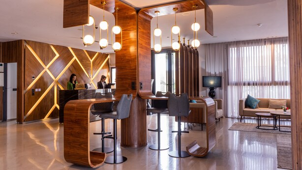A modern hotel lobby with a reception desk, bar area, and seating. - Urban Hotel and Spa (Kenitra)
