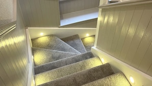 A staircase with carpeted steps and built-in lighting.