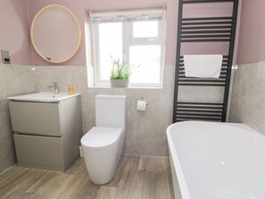 A modern bathroom with a toilet, sink, and bathtub. - Pengwern Bach (Llanrwst)