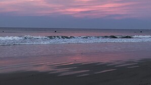 Una playa con olas y un cielo al atardecer.