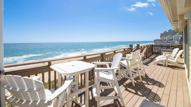 A wooden deck with white chairs and tables overlooking the ocean. - Luxury, Ocean Front, Cargo Lift, 3rd Floor Penthouse KD0003 (Kill Devil Hills)