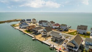 A coastal residential area with houses connected by a dock.