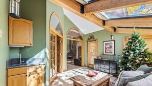 Una sala de estar acogedora con armarios de madera, una chimenea y un árbol de Navidad.