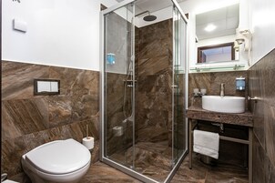 Een douche, handdoeken, zeep, shampoo