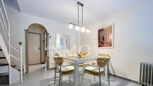 A modern dining area with a glass table, four chairs, and a pendant light. - House in Golf St. Jordi in La Llosa  (Cambrils)