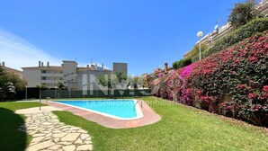 A swimming pool surrounded by well-maintained grass and a stone pathway. - House in Golf St. Jordi in La Llosa  (Cambrils)