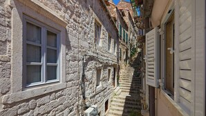 A narrow stone building with a staircase leading to a second floor. - Room Annette - One Bedroom Apartment, Sleeps 2 (Dubrovnik)