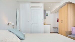 A bedroom with a bed, a wardrobe, a small kitchenette, and a door leading to another room. - Room Annette - One Bedroom Apartment, Sleeps 2 (Dubrovnik)