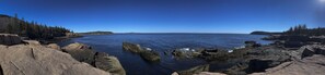 Un paysage côtier caractérisé par des formations rocheuses et une eau d’un bleu limpide.