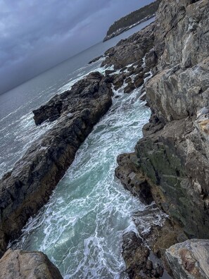 Une côte rocheuse où les vagues déchaînées de la mer s'écrasent contre les rochers.