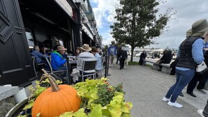 Un restaurante con terraza, un gran centro de mesa con calabaza y vistas a la calle.