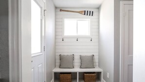 A hallway with a bench, two baskets, and a wooden bat hanging above. - ⛵️Coastal Retreat at Tech Terrace 3/2 Remodeled 2 Kings (Lubbock)