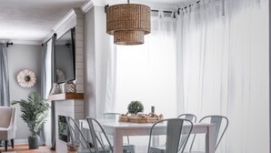 A dining area with a white table, grey chairs, and a woven pendant light. - ⛵️Coastal Retreat at Tech Terrace 3/2 Remodeled 2 Kings (Lubbock)
