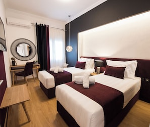 A hotel room with two beds, a desk, a chair, a round mirror, and a hanging light fixture. - Acropolis Panoramic View Exclusive Apartment | 3 Falirou str 11742 Athens (Athens)