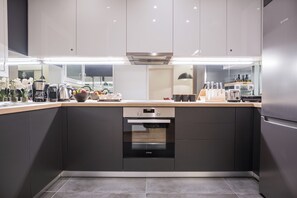 A modern kitchen with a built-in oven, a coffee maker, and a microwave.