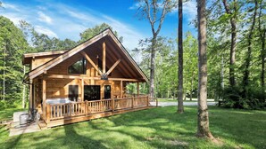 Een houten chalet met balkon, omringd door bomen.