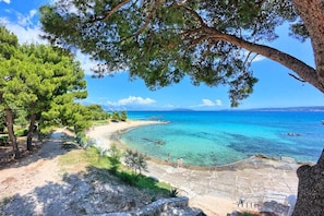 A coastal path leading to a beach with clear turquoise waters and a distant view of the sea. - Summer Seaside Pearl Apartment Kastela (Kastela)