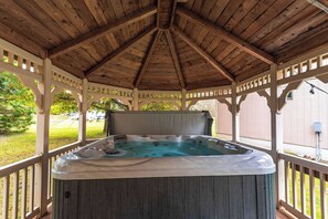A hot tub under a wooden gazebo with a view of a grassy yard. - Antler Ridge: 3BDR w/ Hot Tub & Game Room (Penn Forest Township)