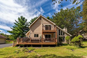 A two-story house with a balcony, a garage, and a well-maintained lawn.