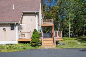 A two-story building with a wooden deck and a small staircase leading to a balcony. - Antler Ridge: 3BDR w/ Hot Tub & Game Room (Penn Forest Township)