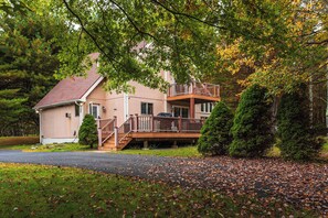 A two-story house with a balcony, surrounded by trees and a driveway. - Antler Ridge: 3BDR w/ Hot Tub & Game Room (Penn Forest Township)