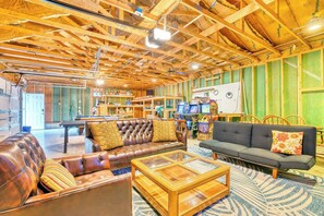 A spacious living area with leather sofas, a glass coffee table, and a green wall with a whiteboard. - Antler Ridge: 3BDR w/ Hot Tub & Game Room (Penn Forest Township)