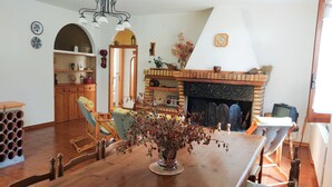 Ein Essbereich mit Holztisch, Stühlen, Kamin und Spiegel.