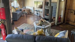 A cozy living room with a fireplace, a sofa, a TV, and a dining area.