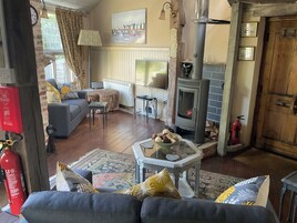 A cozy living room with a fireplace, a sofa, a TV, and a dining area.